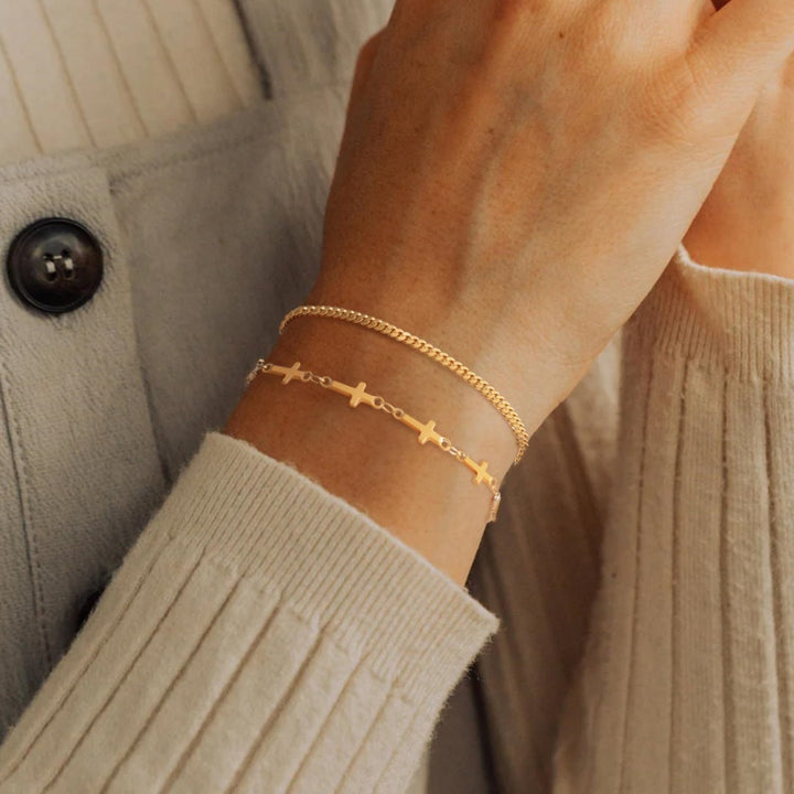 Elegant gold layered cross charm bracelet for women, with white beads. Adjustable spiritual fashion jewelry.