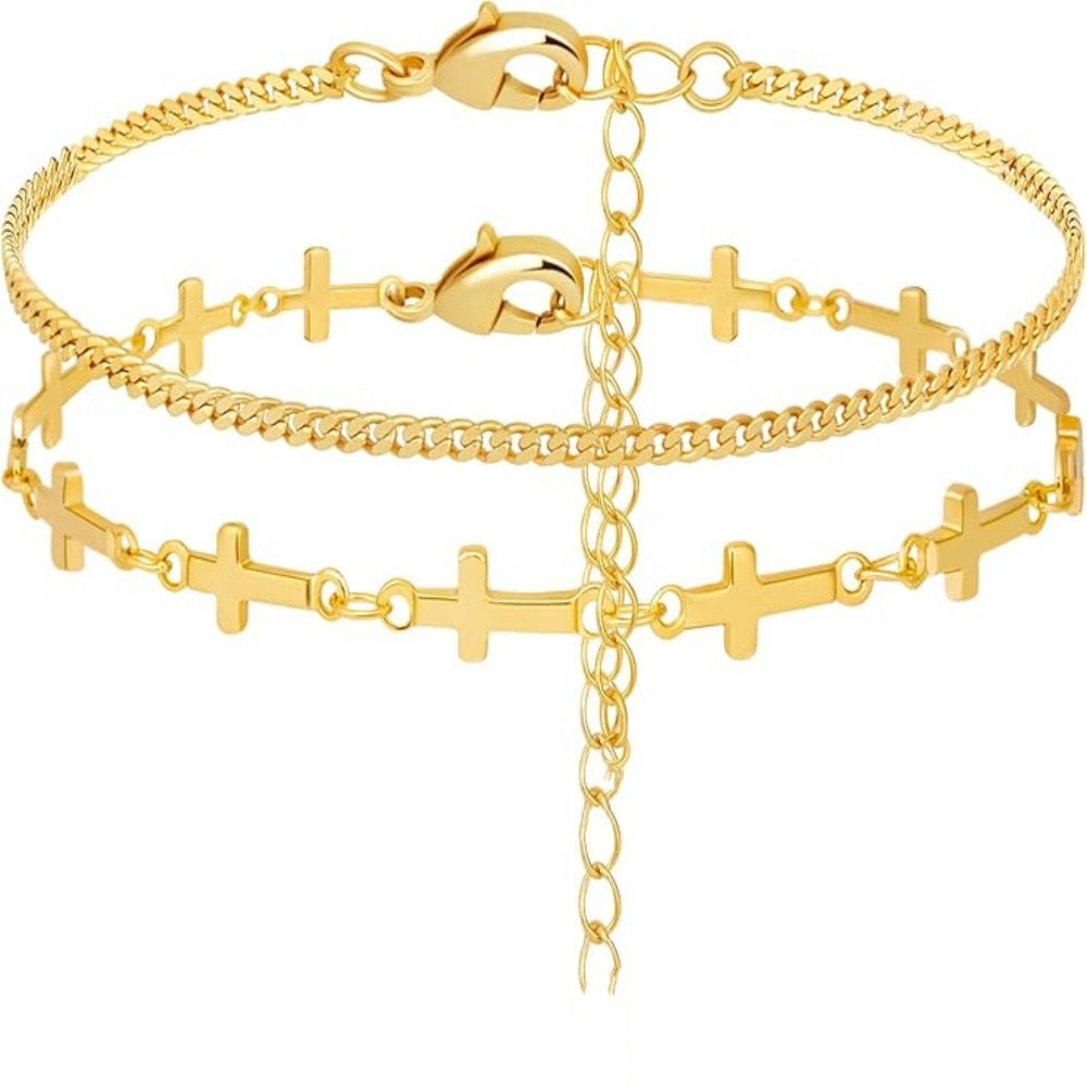 Delicate gold layered bracelet for women, featuring a spiritual cross charm and small white decorative elements.