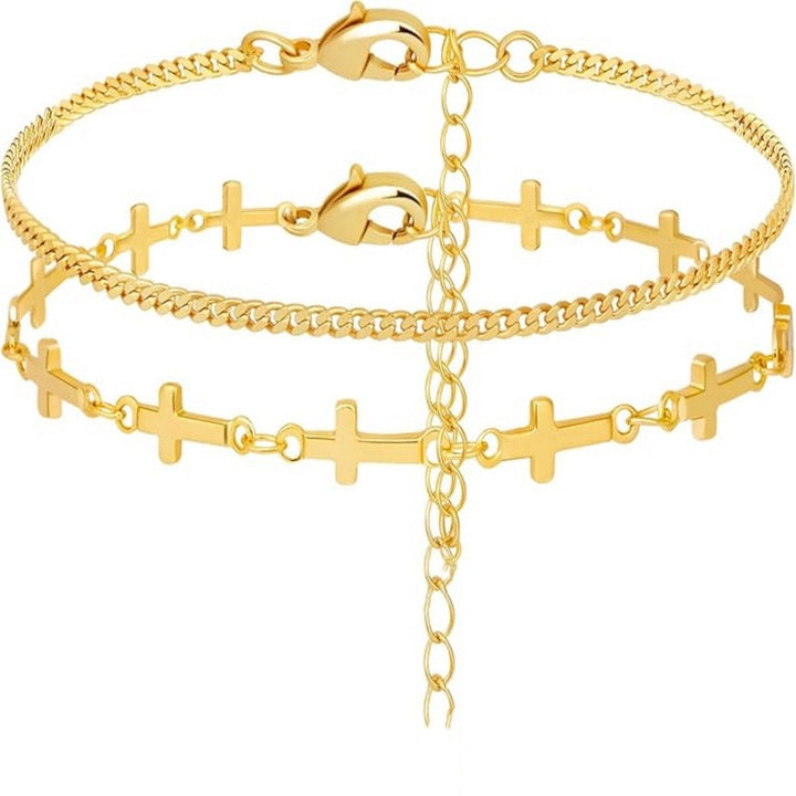 Delicate gold layered bracelet for women, featuring a spiritual cross charm and small white decorative elements.