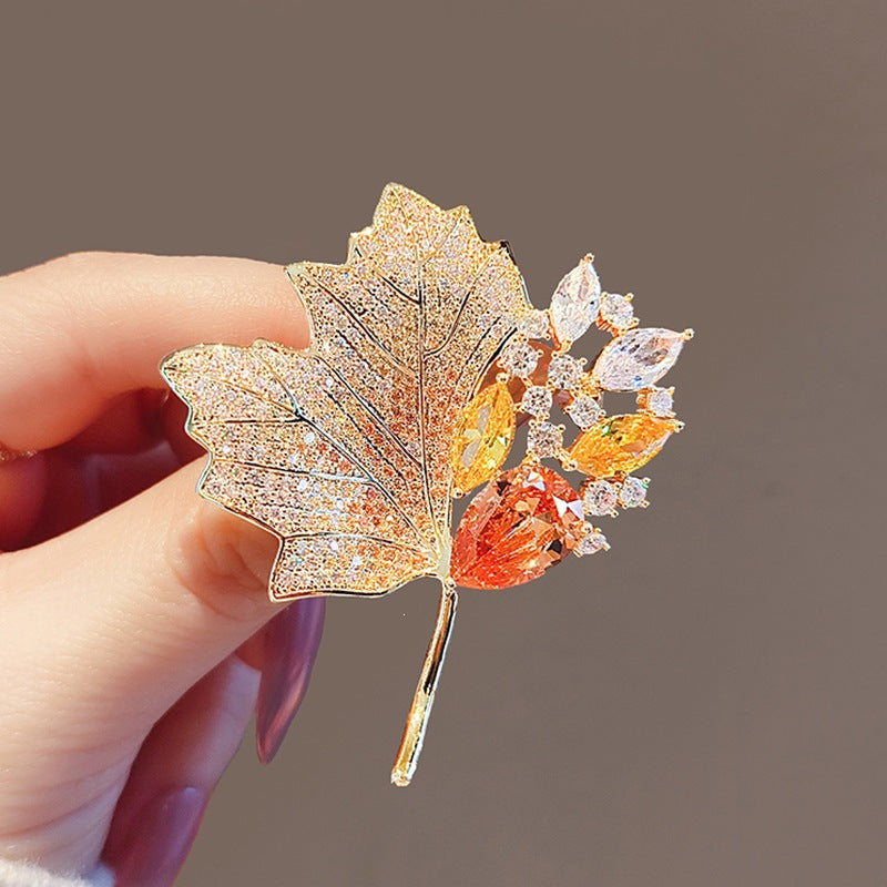 Elegant gold plated crystal leaf brooch for women, nature-inspired jewelry accessory.