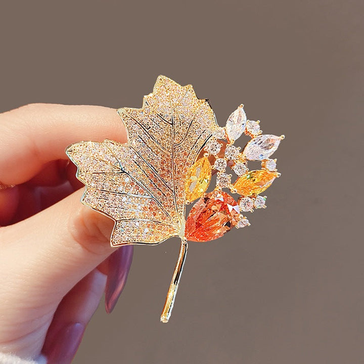 Elegant gold plated crystal leaf brooch for women, nature-inspired jewelry accessory.