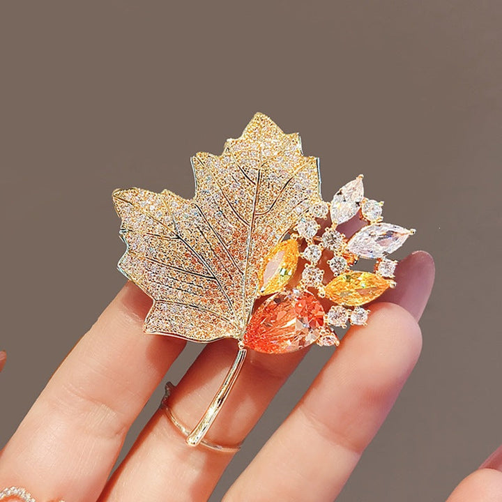 Nature-inspired elegant crystal leaf brooch, perfect gold plated accessory for women.