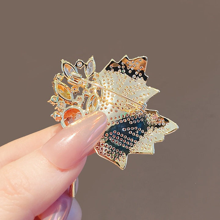 Women's elegant gold plated crystal leaf brooch pin, a beautiful nature-inspired jewelry gift.