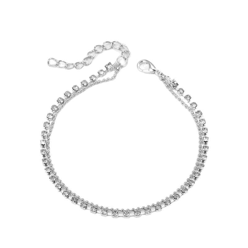 Stylish women's layered anklet, an elegant foot accessory. Gold-tone double chain for modern fashion.