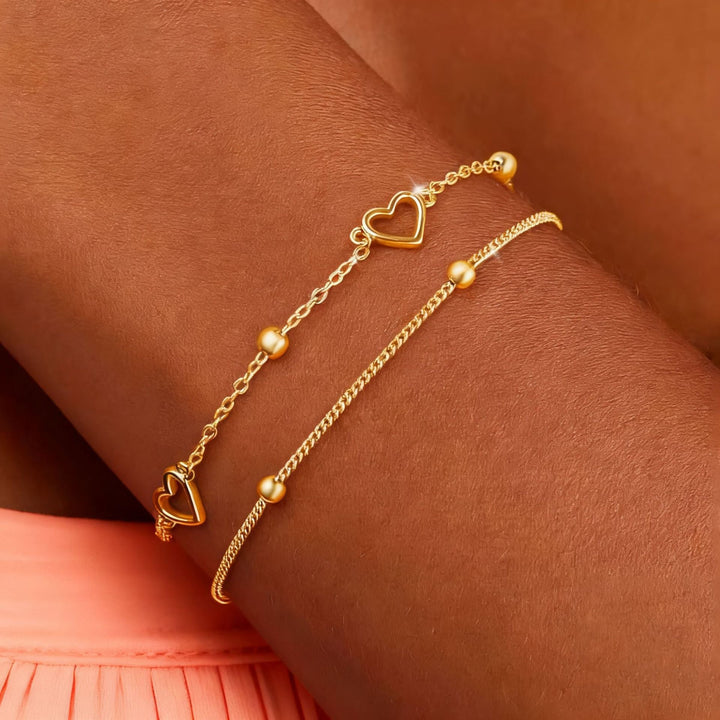 Women's elegant gold tone layered bracelet with small heart charm, a stylish and adjustable fashion accessory.