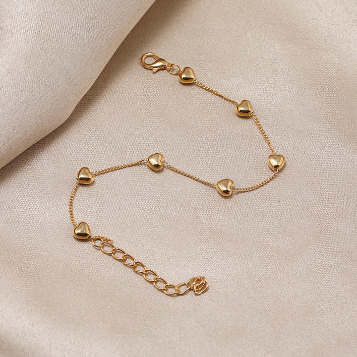 Gold-tone women's bracelet featuring a beautiful heart charm. Chic and elegant jewelry, ideal as a gift.