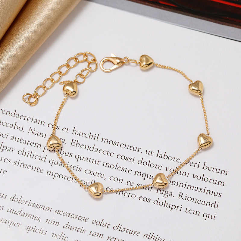 Adjustable gold-tone bracelet for women, adorned with a romantic heart charm. Perfect elegant accessory or gift.
