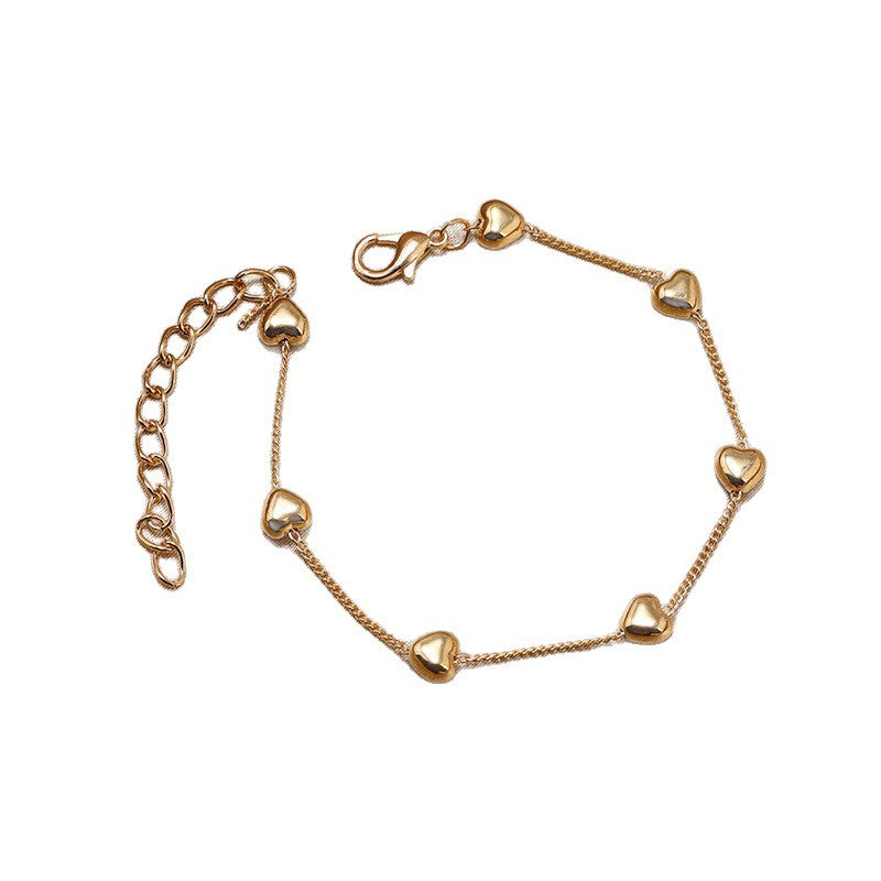 Stylish gold-tone women's bracelet with a heart charm. Elegant and versatile jewelry for everyday or special events.