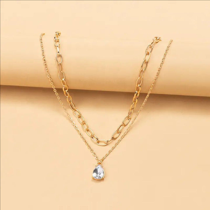 Women's layered gold chain necklace with white links, an elegant jewelry gift for her.