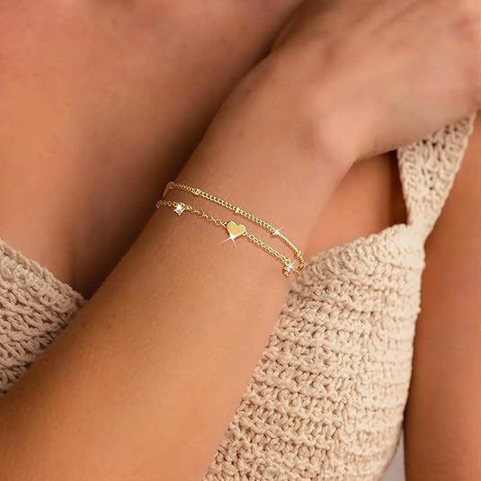 Gold tone adjustable chain bracelet for women with elegant heart and star charm accents.