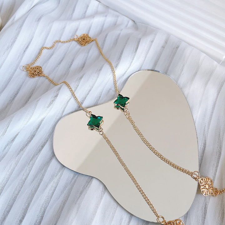 Close-up: Elegant green stone necklace, women's jewelry showcasing a brilliant, sparkling gemstone.