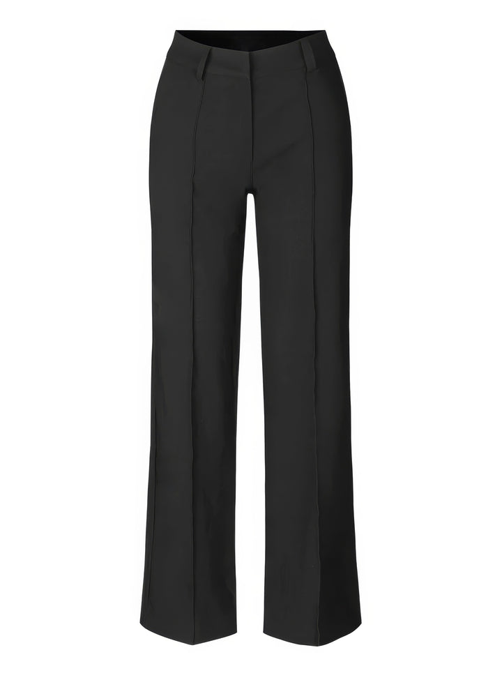 Woman walking in flowing high-waisted wide-leg trousers, displaying comfortable movement.