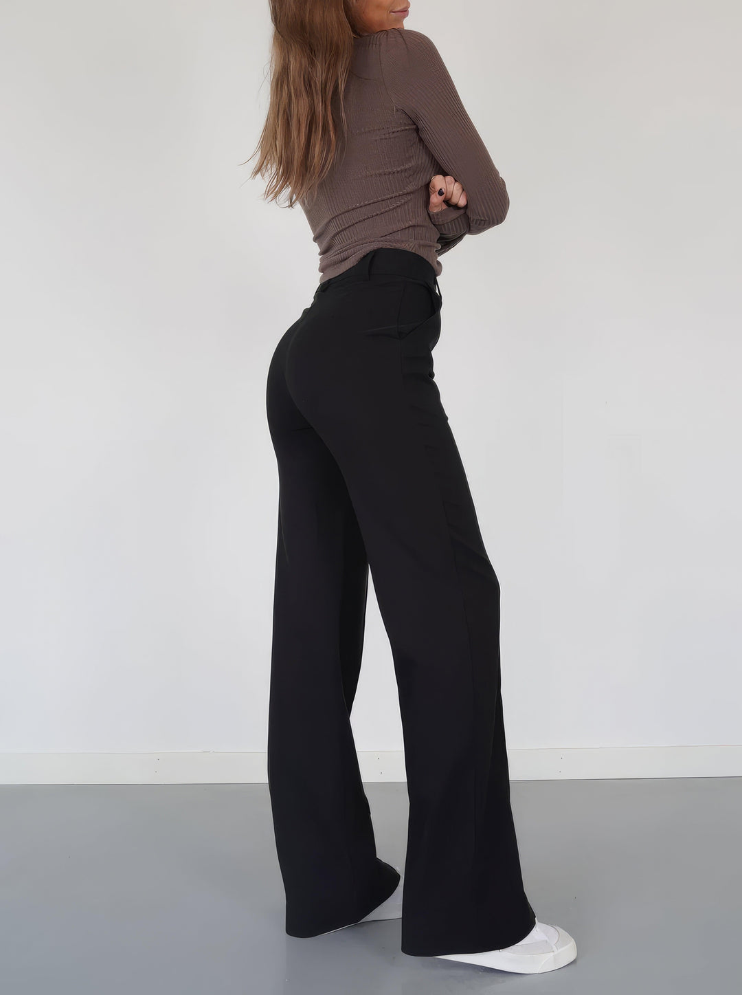 Black high-waisted wide-leg trousers, ideal for women's elegant workwear & casual chic.
