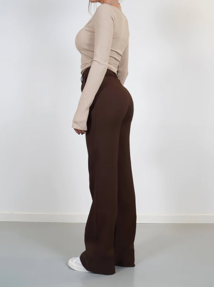 Detail shot: Luxurious fabric of high-waisted wide-leg trousers, a women's fashion staple.