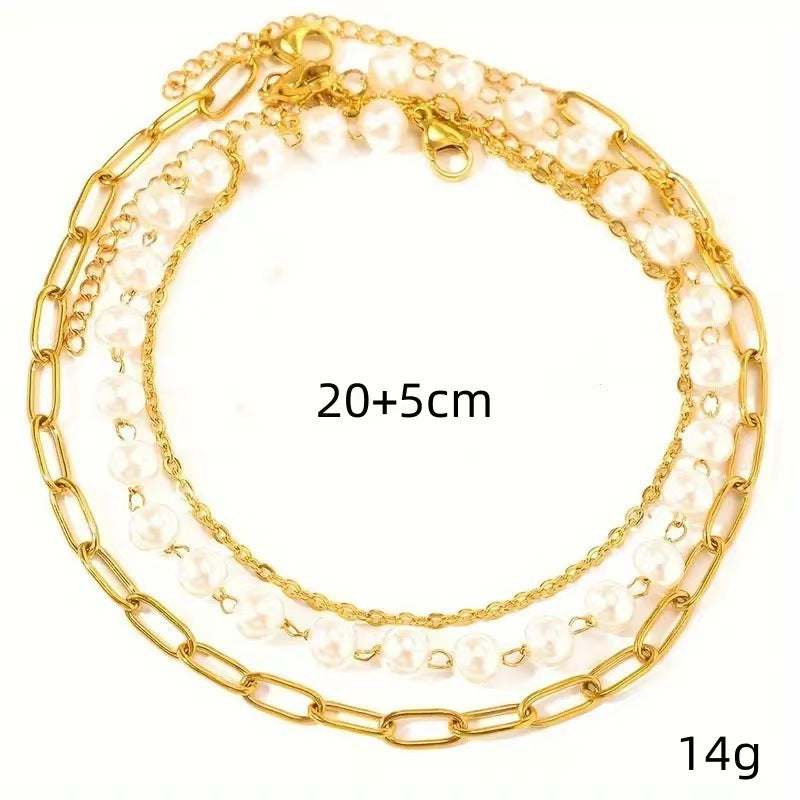 Fashionable women's layered bracelet set with faux pearls and gold-tone chains. Elegant adjustable jewelry.