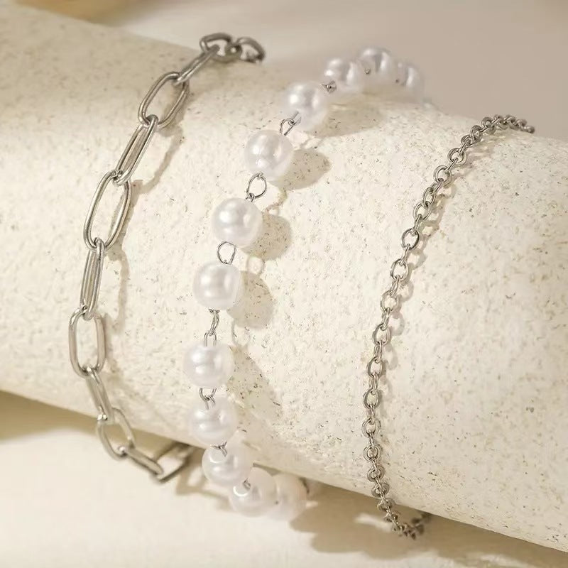 Delicate women's layered pearl & chain bracelet set. Elegant and adjustable fashion jewelry, ideal for gifts.