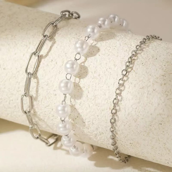 Delicate women's layered pearl & chain bracelet set. Elegant and adjustable fashion jewelry, ideal for gifts.