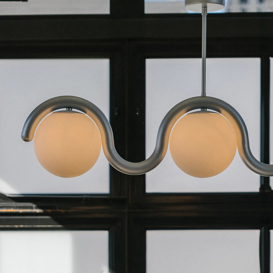 Modern linear chandelier, adjustable height with glass shades, perfect for dining areas.