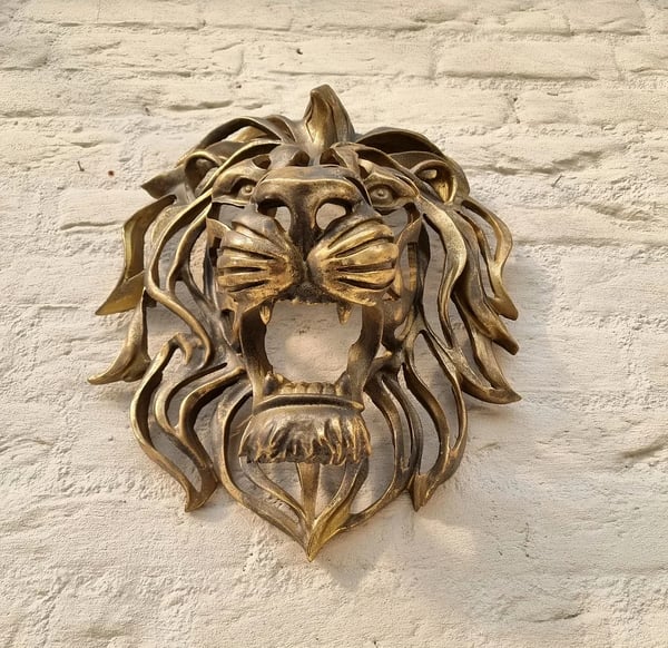 Detailed metal lion head home accent, perfect as a stylish wall decor sculpture for modern interiors.