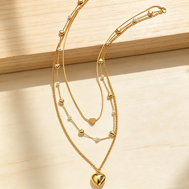 Stylish multi-layered women's necklace featuring a heart pendant and delicate alloy chains with small beads.