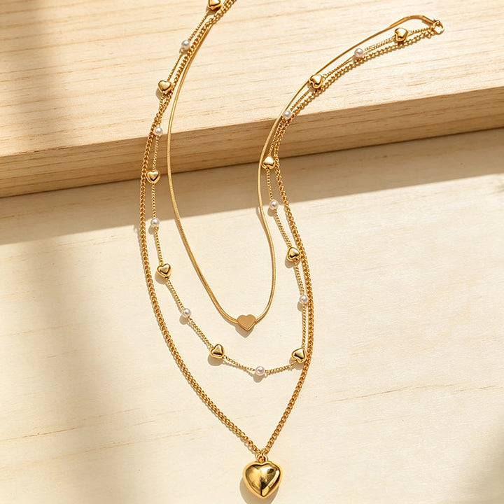 Stylish multi-layered women's necklace featuring a heart pendant and delicate alloy chains with small beads.