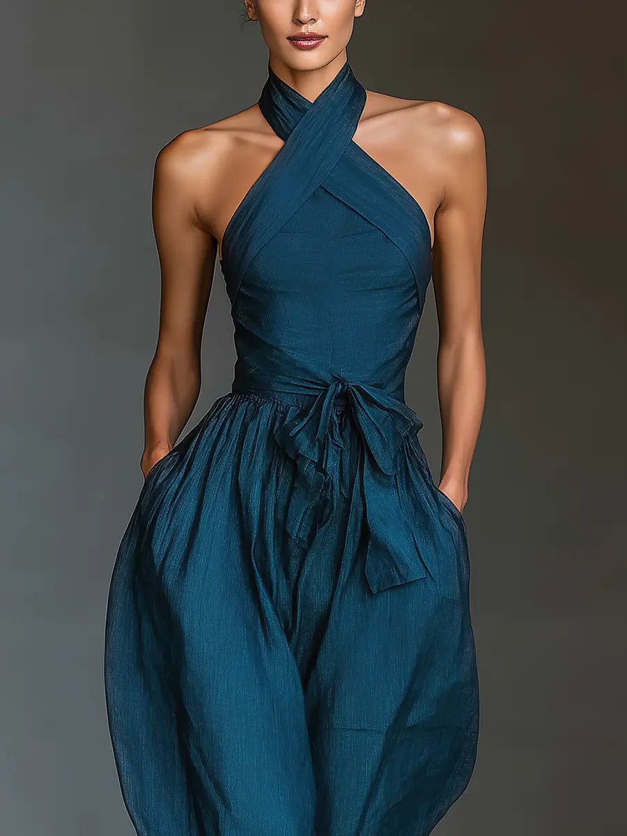 Stylish navy blue sleeveless wide-leg jumpsuit for women, featuring a chic cross halter neck and tie waist.