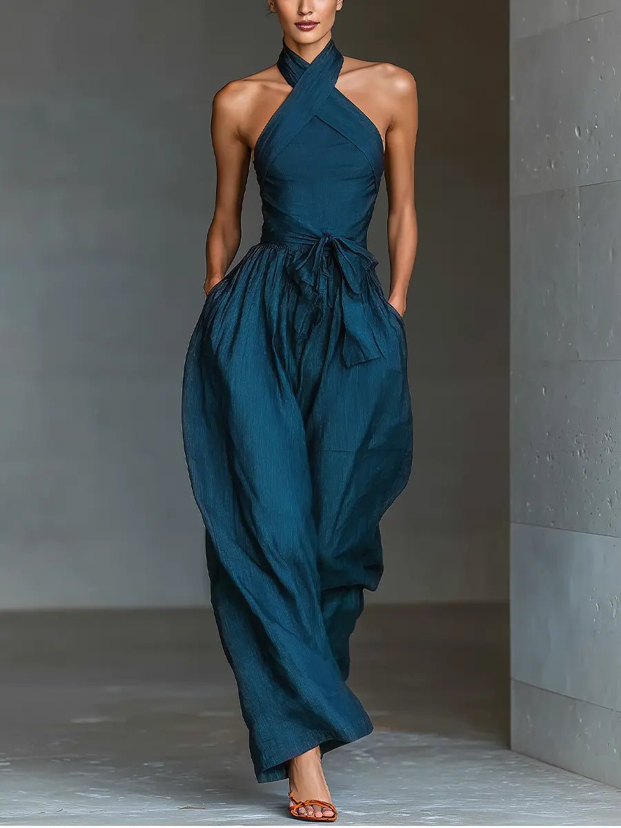 Elegant navy blue women's halterneck wide-leg jumpsuit with tie waist & pockets. Perfect for summer casual or evening.