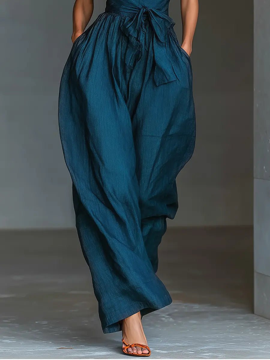Stylish women's navy blue halter jumpsuit with wide legs, ideal for warm weather, offering an elegant one-piece outfit.