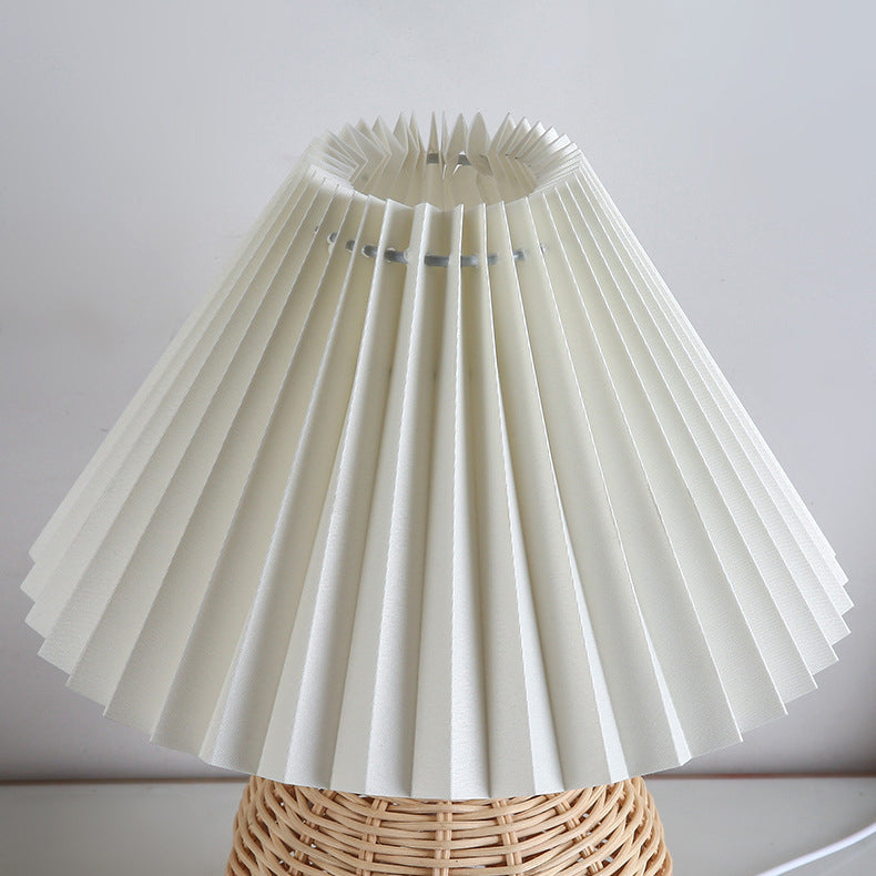 Soft glow LED table lamp, natural rattan and fabric shade, perfect for bedroom mood.