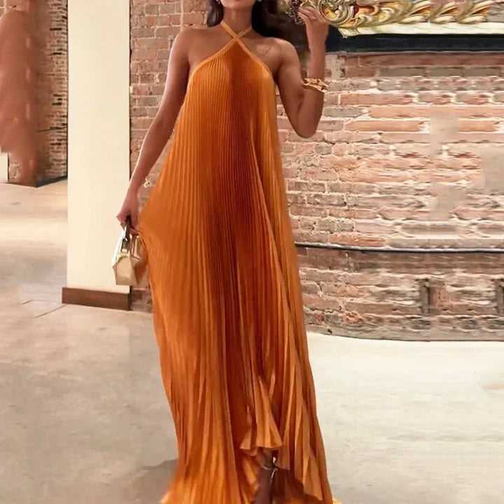 Women's elegant halter maxi dress in orange, featuring delicate pleats. Ideal as a wedding guest or party dress.
