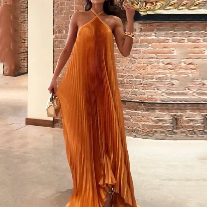 Women's sleeveless orange pleated maxi dress with a sophisticated halter neck, ideal for party or occasion wear.