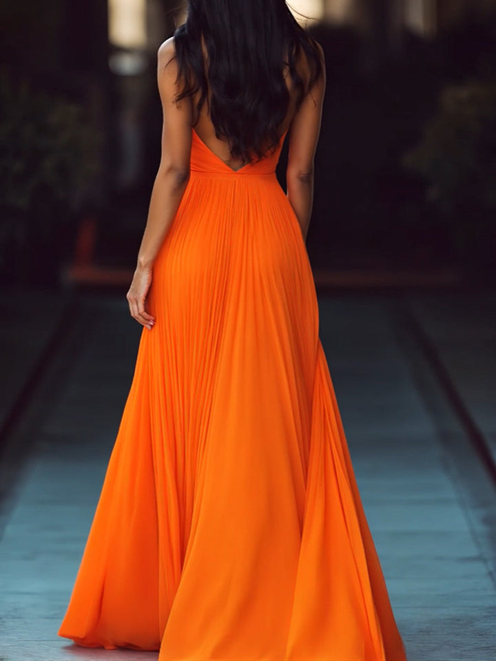Flowy orange V-neck maxi dress with a halter neckline & elegant pleats, perfect for evening or special occasions.