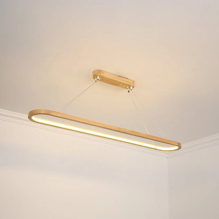 Designer oval pendant light, natural wood grain & smooth acrylic, creates inviting ambiance.