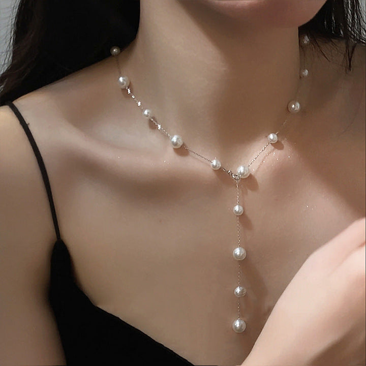 Elegant pearl drop lariat necklace for women, delicate gold chain and lustrous white freshwater pearls.