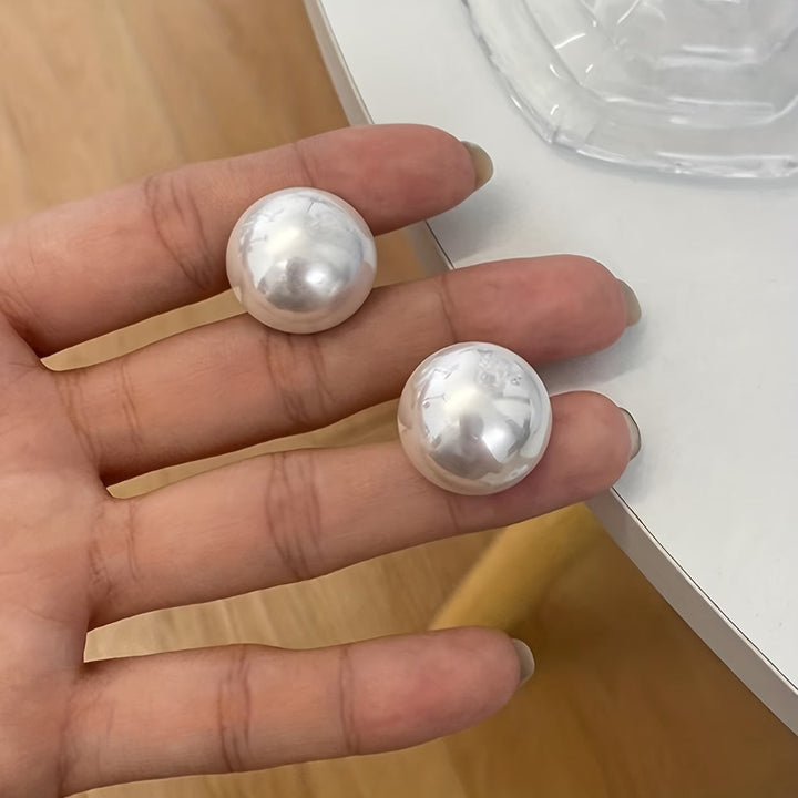 Classic women's pearl stud earrings, sophisticated and elegant accessory. Ideal for everyday or special occasions.