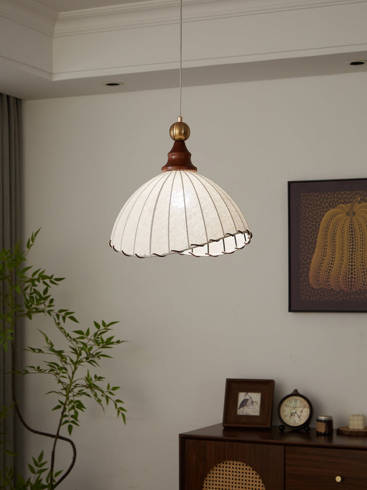 Beautiful pendant light showcasing an elegant fabric shade, gold highlights, and wood.