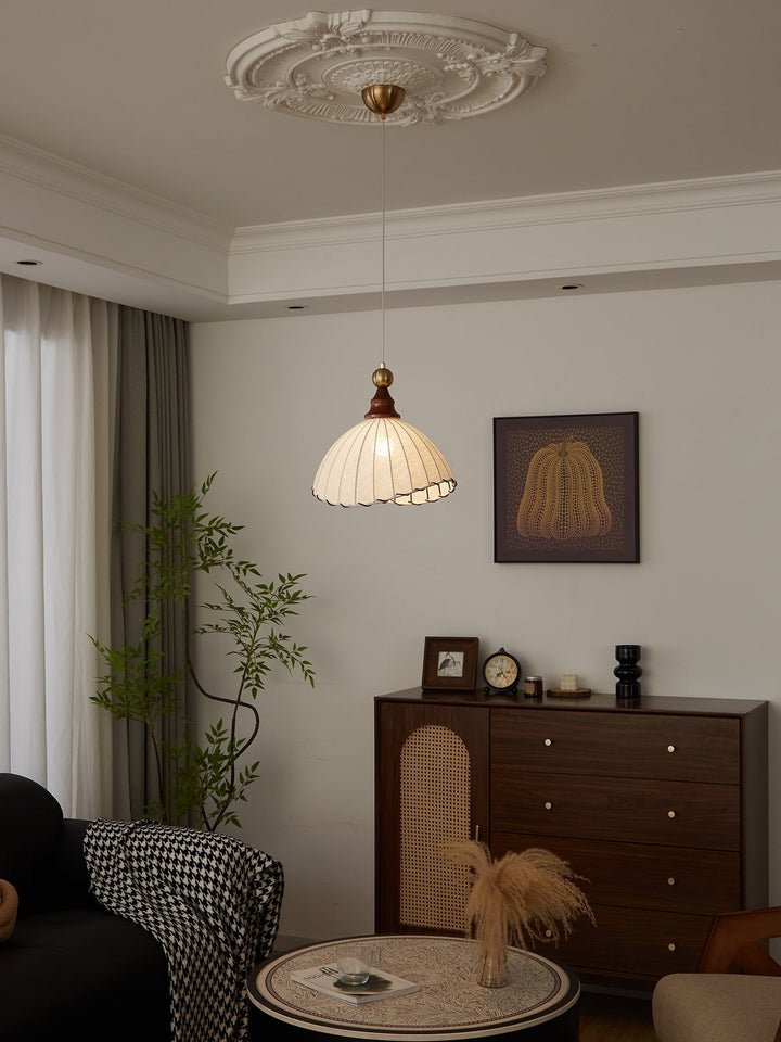 Elegant ceiling fixture; fabric shade, gold-tone metal, and organic wood design.
