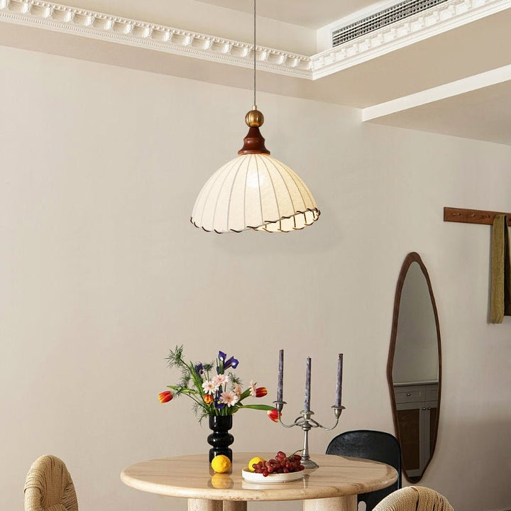 Timeless pendant light; ambient fabric shade, gold-tone metal, and subtle wood elements.