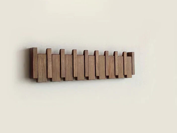 Contemporary piano key wall rack in walnut wood. Multi-hook coat hanger for stylish, organized home entryways.