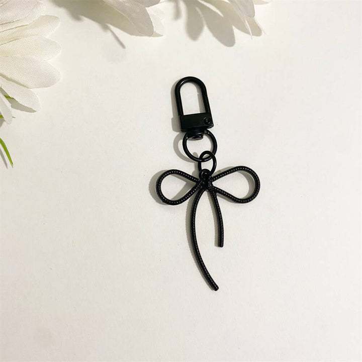 Stylish red bow key holder, a vibrant & elegant bag accessory for women.