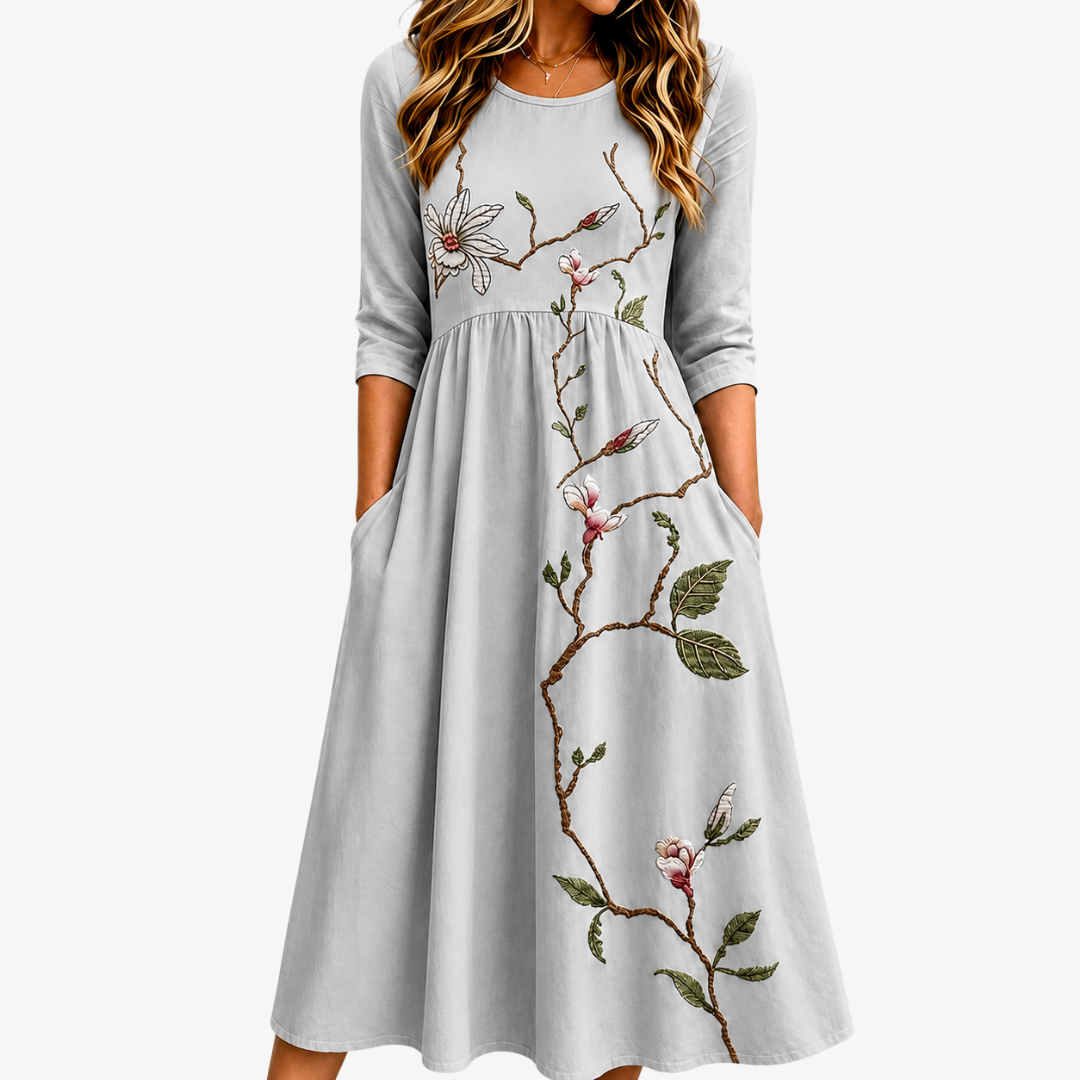 Elegant sage green women's midi dress with blossom floral print, practical pockets, & comfortable A-line fit.