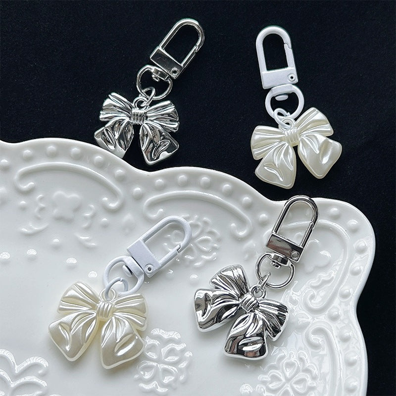 Elegant silver bow pendant charm, perfect for women's necklaces or as a stylish accessory for bags and keychains.