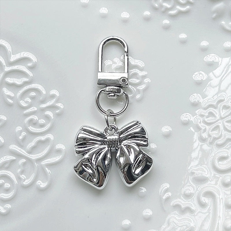 Delicate pearl-white bow charm pendant for women, adding an elegant touch to any necklace, bracelet, or bag.