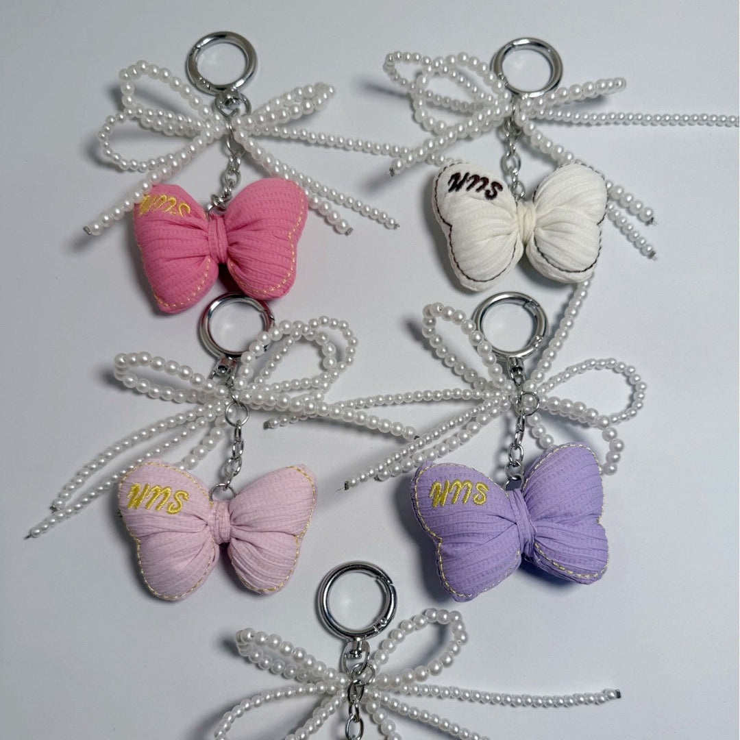 Elegant silver butterfly keychain with pearl charm, perfect for bags or keys.