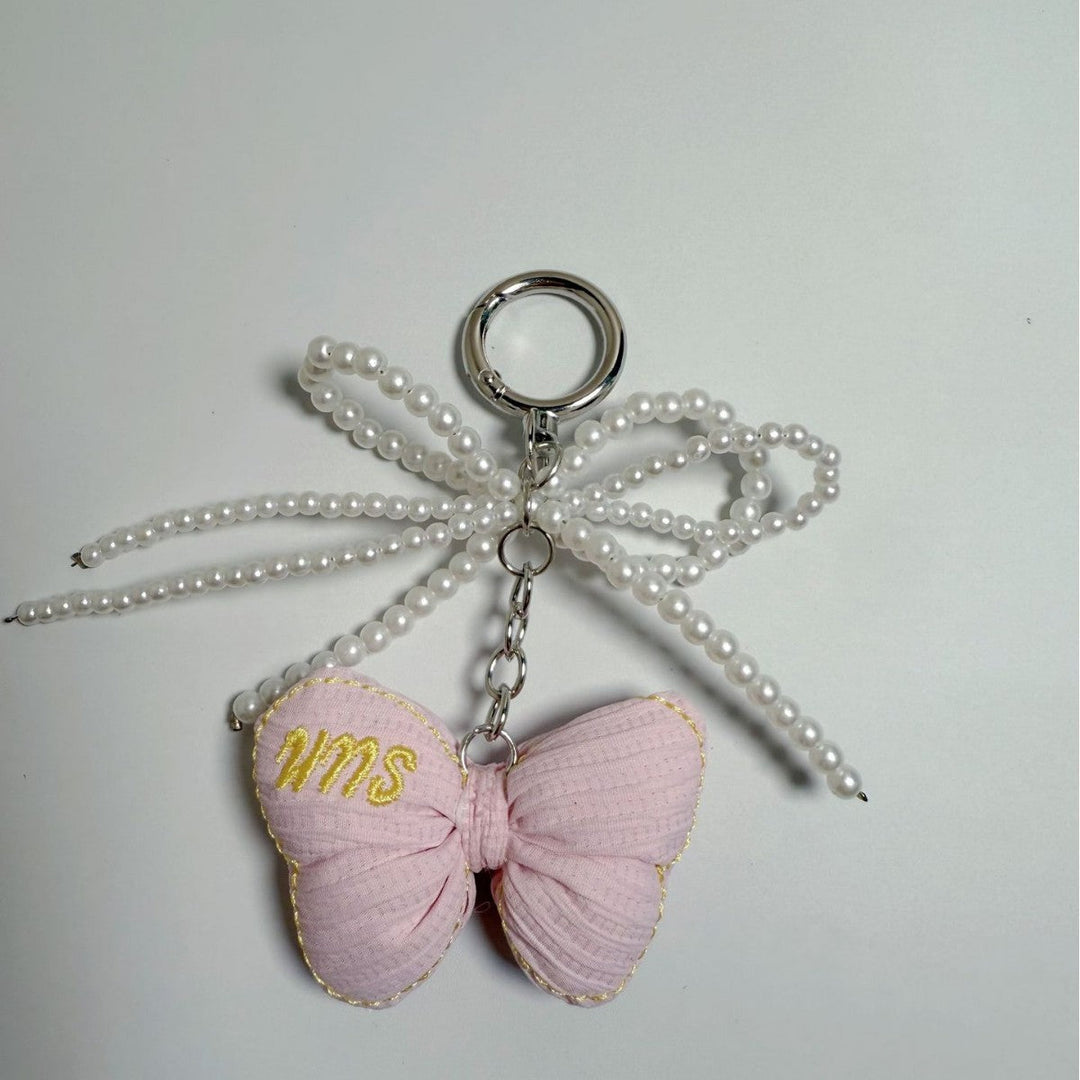 Detailed butterfly key accessory, elegant charm with pearl for stylish women.
