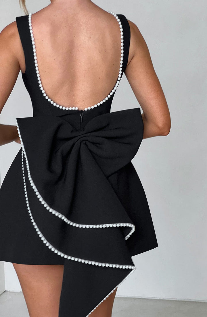 Fashionable sleeveless mini wedding guest dress. Elegant women's party wear for special events.