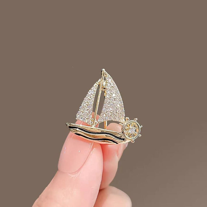 Stylish sparkling sailboat brooch, an elegant women's nautical pin accessory.