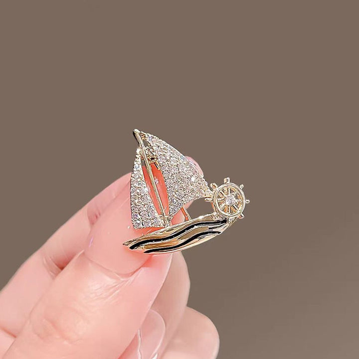 Intricate sparkling sailboat pin with crystals, elegant women's nautical brooch jewelry.