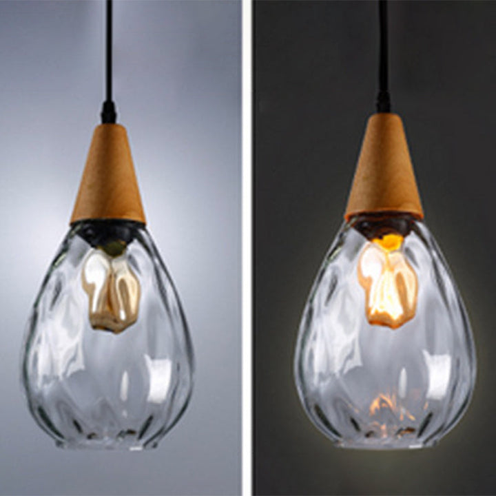 Warm glow from elegant teardrop glass pendant light, modern ceiling lamp for cozy ambiance.