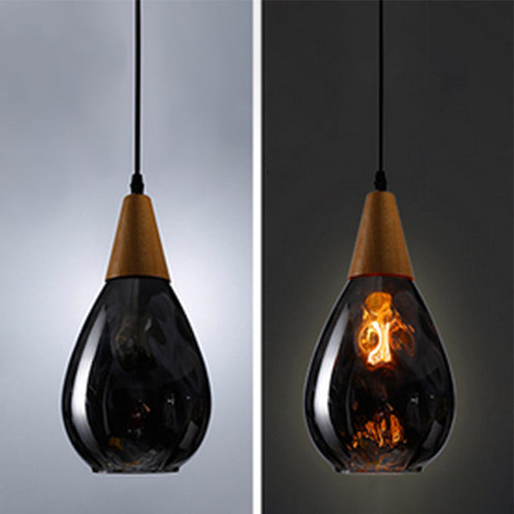 Modern teardrop glass pendant light, ideal kitchen island lighting with wood detail.